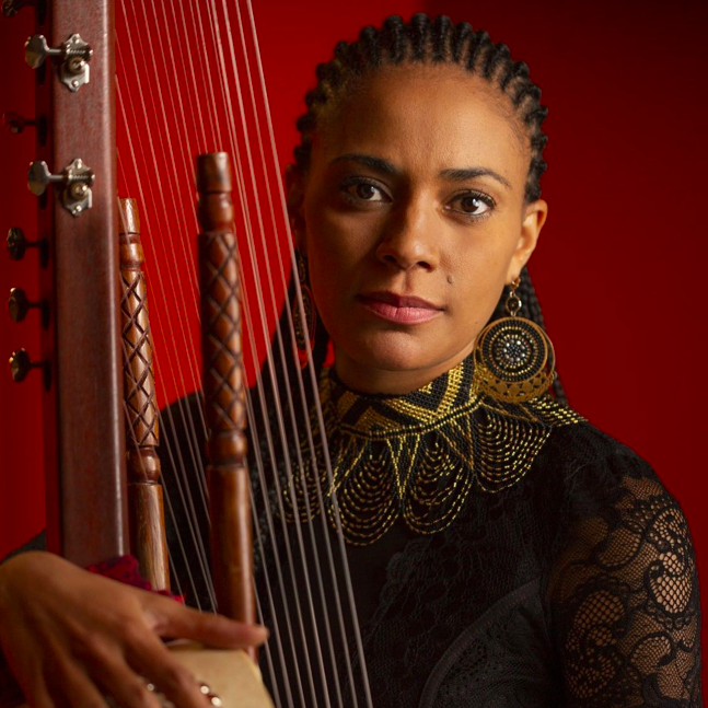 Sona Jobarteh holding her stringed instrument of choice, the Kora.