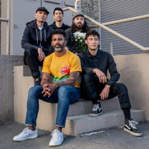 The band Drought sitting on stairs outside.