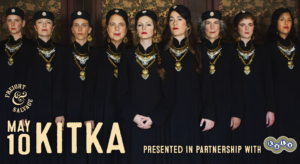 The eight women of Kitka hugging each other in a line while facing the camera.