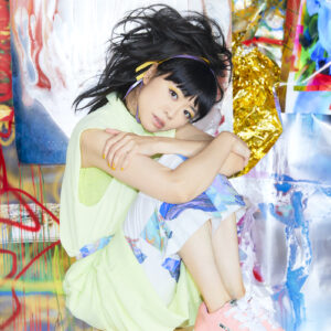 Hiromi tucked onto a ball with a graffiti background.