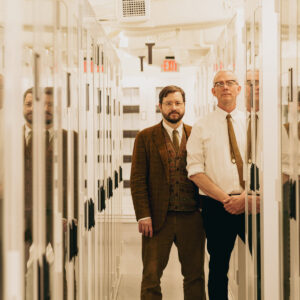 Matmos standing together in a hallway of storage.