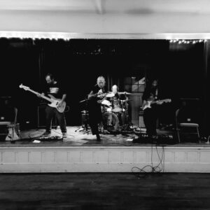 black and white photo of a rock band (Trough) performing