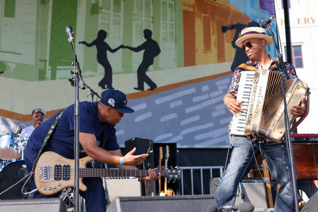 Corey Ledet playing the accordion on stage with guitarist