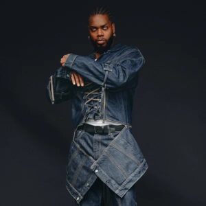 serpentwithfeet standing in all denim with black background.