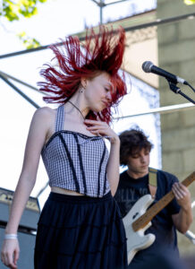 Maddie Gartland, vocalist of The Kissing Disease, dancing on stage in front of the guitarist