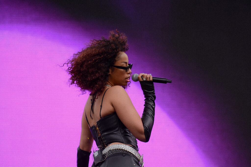 A woman singing on stage in front of a large screen