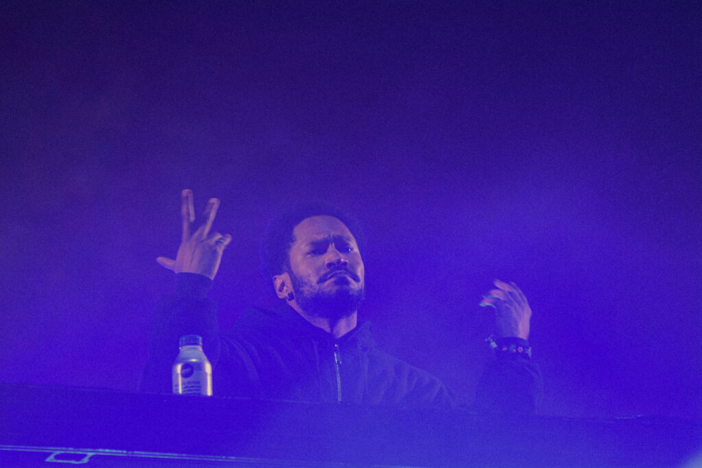 Musician at his instrument both hands in the hair at night on an outdoor stage