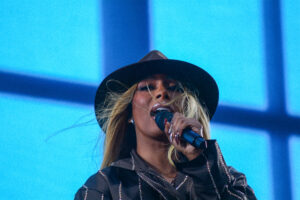 Woman singing into a microphone on stage