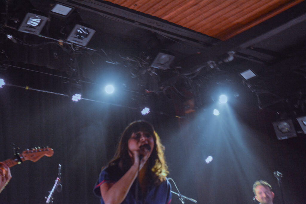 Woman singing into a microphone on stage