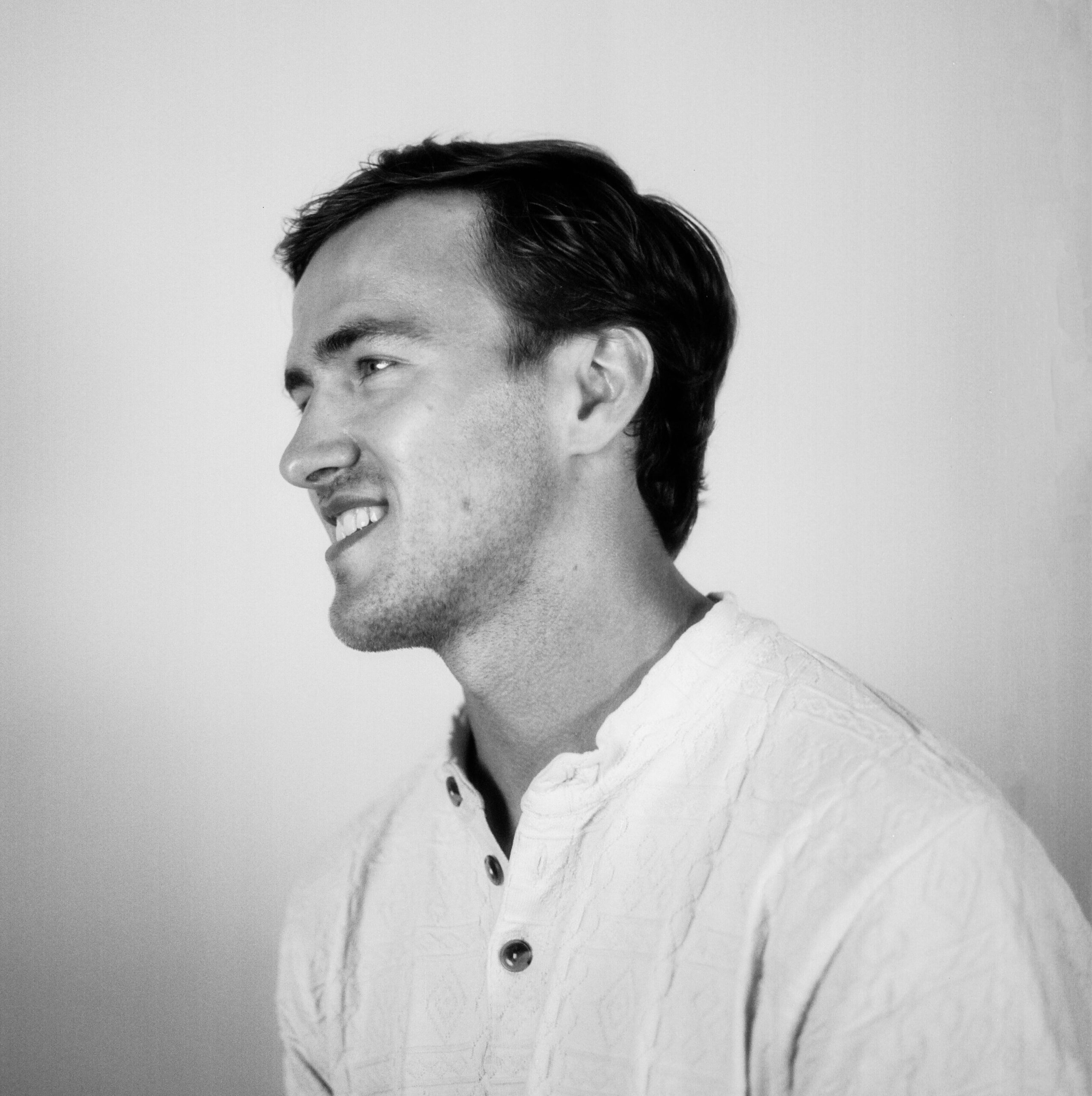 Black and white press photo of a man facing to the side