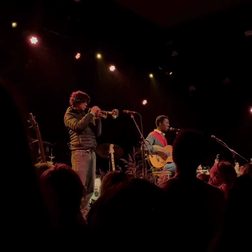 Trumpet player (left) and acoustic guitar played while sitting (right) on stage