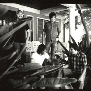 B&W photo of band outside.