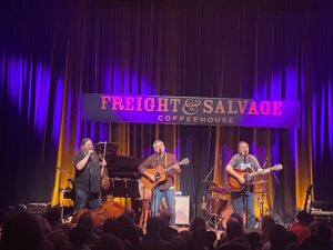 Box Set trio performing on stage at Freight & Salvage in Berkeley, from left to right playing violin and two acoustic guitars