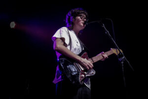 Lunar Vacation's Gep Repasky singing, playing guitar on stage