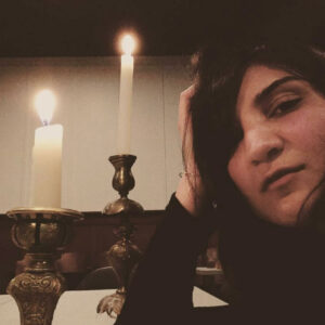 Sarah Davachi with candles in the background.